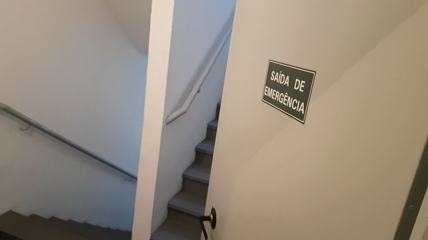 escadas de emergência com porta sinalizada para rota de fuga